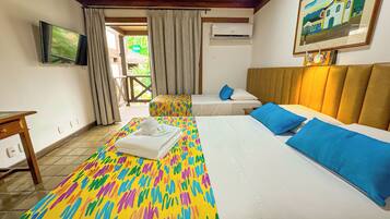 Quarto de hotel com duas camas, televisão, aparelho de ar condicionado e um quadro na parede.