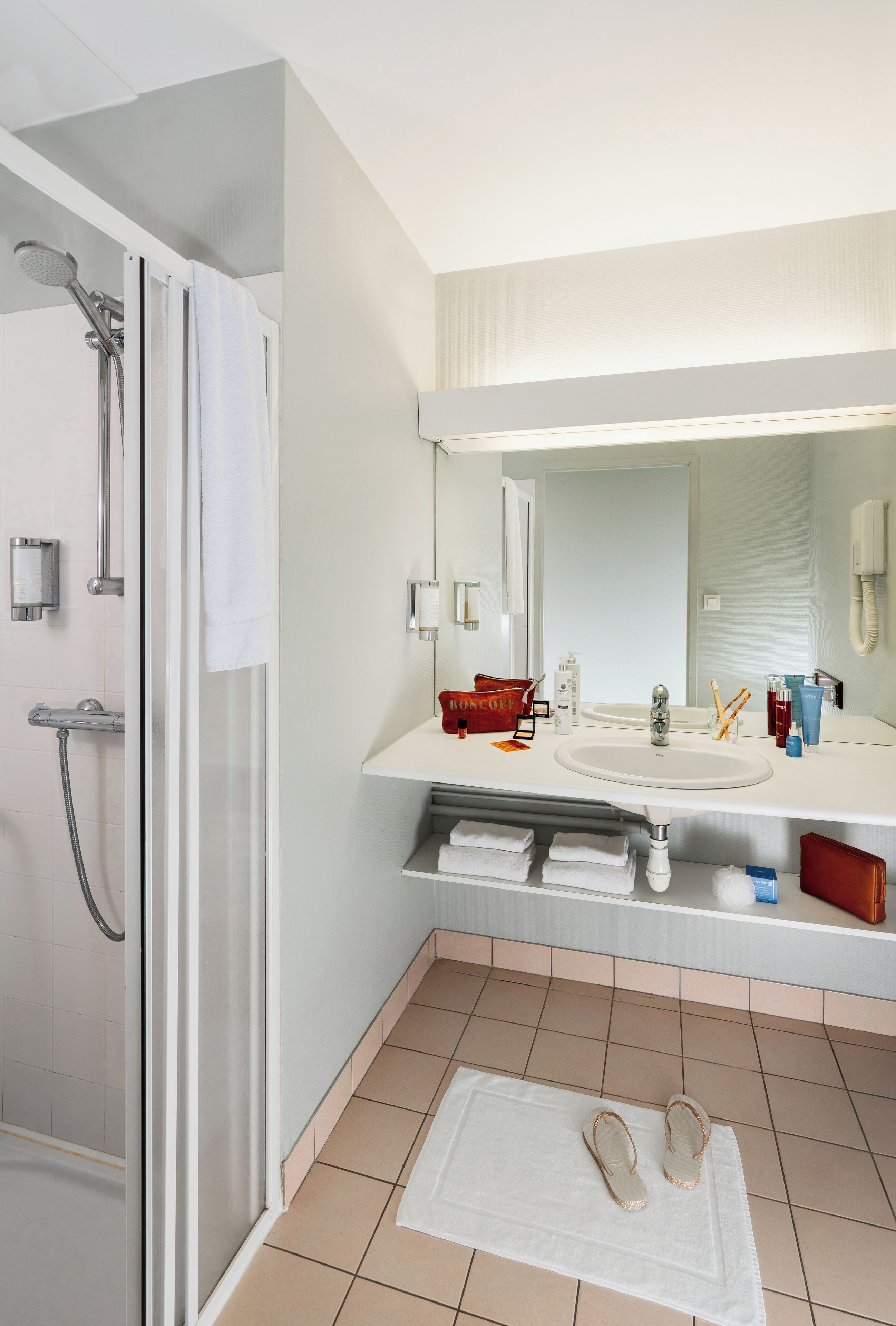 A modern bathroom with a shower, a sink, and a mirror.