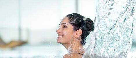 A person in a hot tub with water splashing around them.
