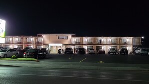 Un motel comprenant plusieurs chambres, un parking et un panneau indiquant le nom « Motor Inn ».