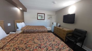 Una habitación de hotel con dos camas, un aparador, una silla, un televisor y un microondas.