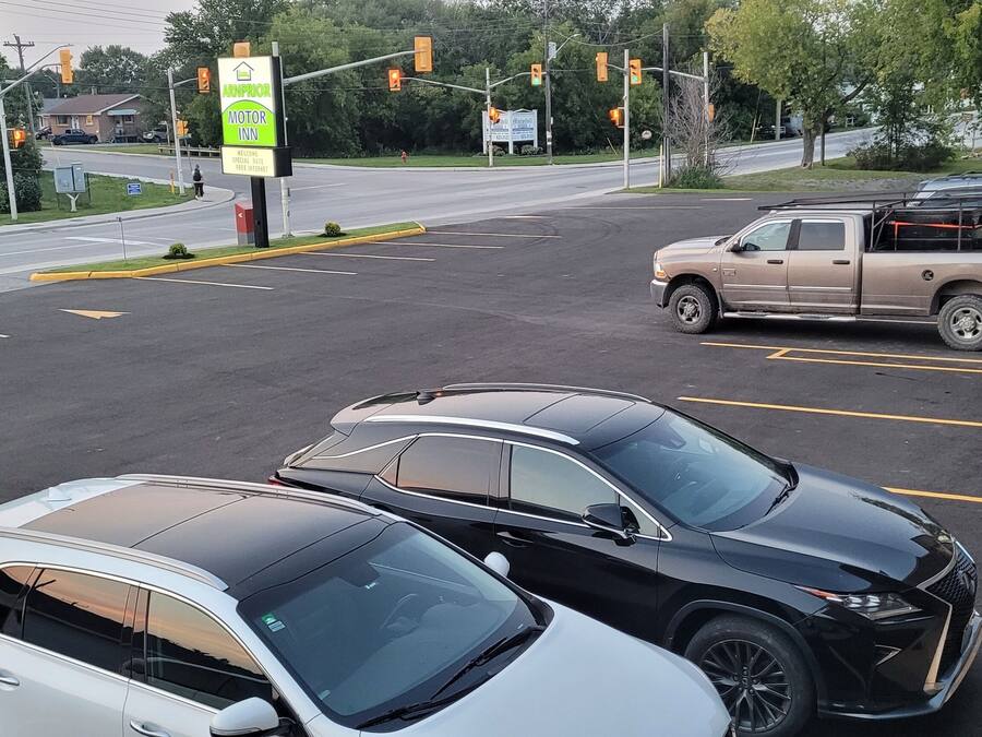A parking lot with several cars, including a white SUV and a black SUV, and a pickup truck.