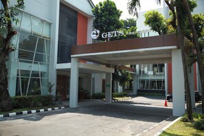 Un bâtiment moderne doté d’une entrée couverte, de grandes fenêtres et d’une enseigne sur laquelle on peut lire : « GETS PREMIERE ».