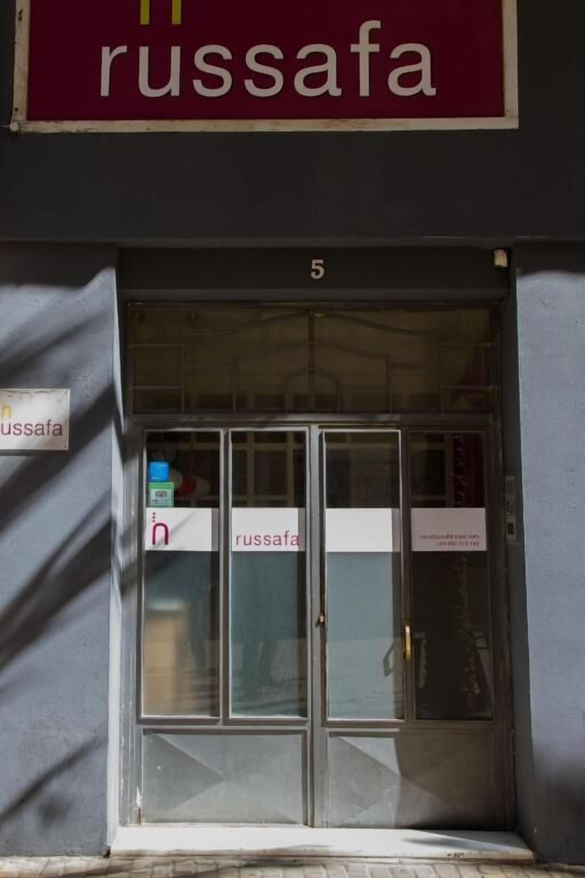 L’entrée d’un immeuble, avec une enseigne portant l’inscription « Russafa » au-dessus de la porte.