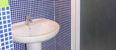 A bathroom with a sink, a mirror, and a window.