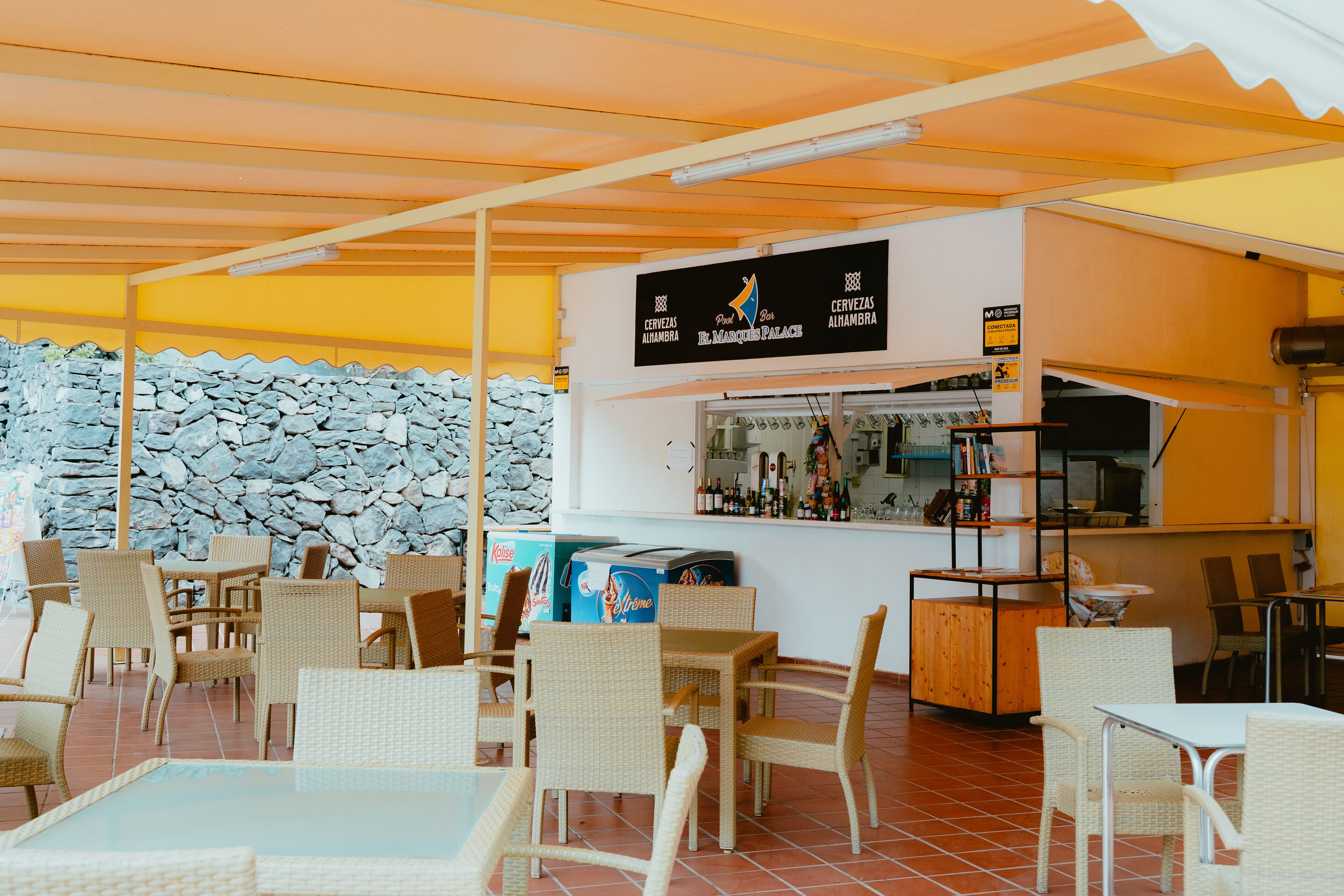 Un espace extérieur aménagé avec des meubles en osier et un comptoir de bar.