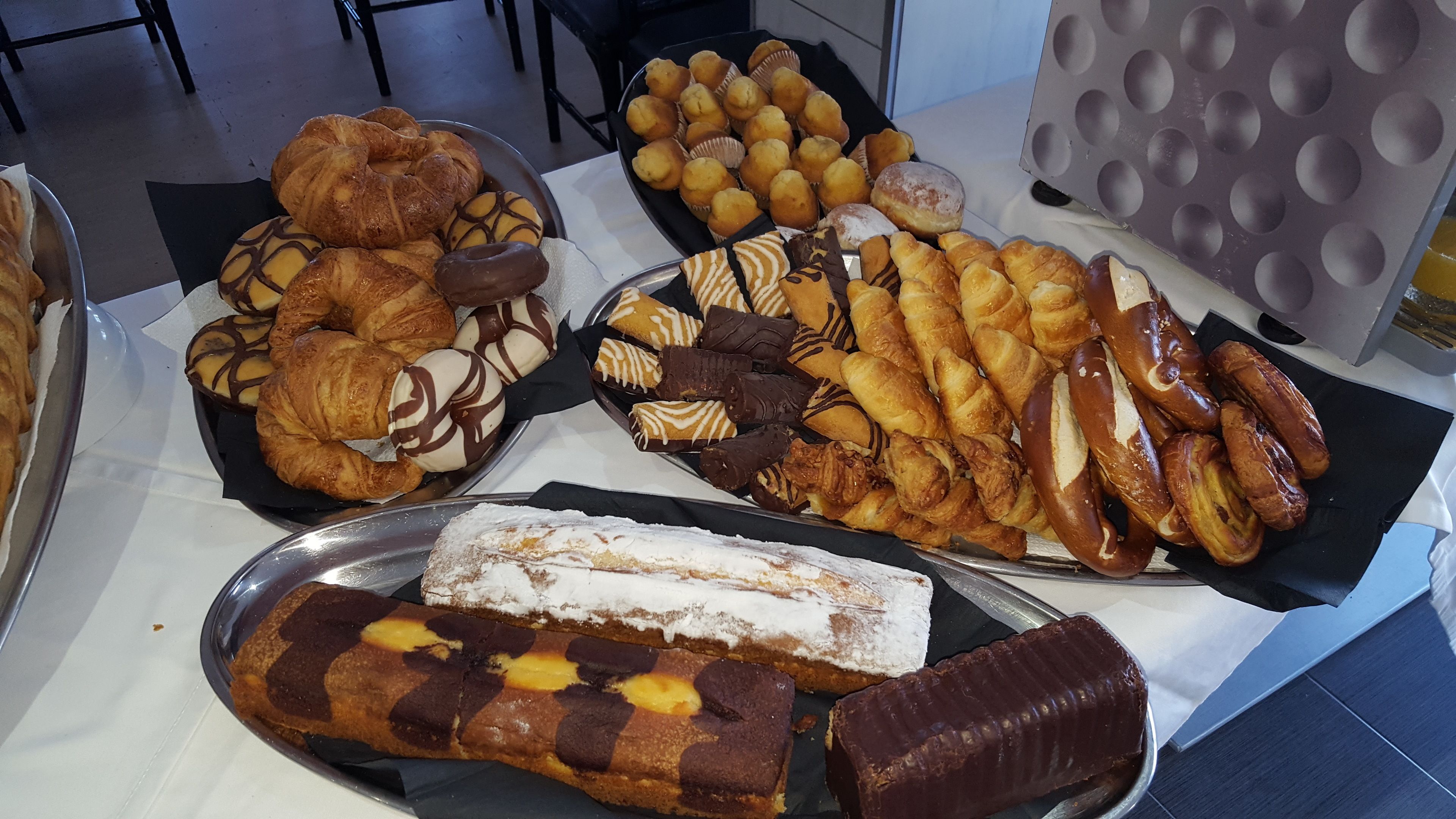 Verschillende gebakjes en desserts, gepresenteerd op dienbladen.
