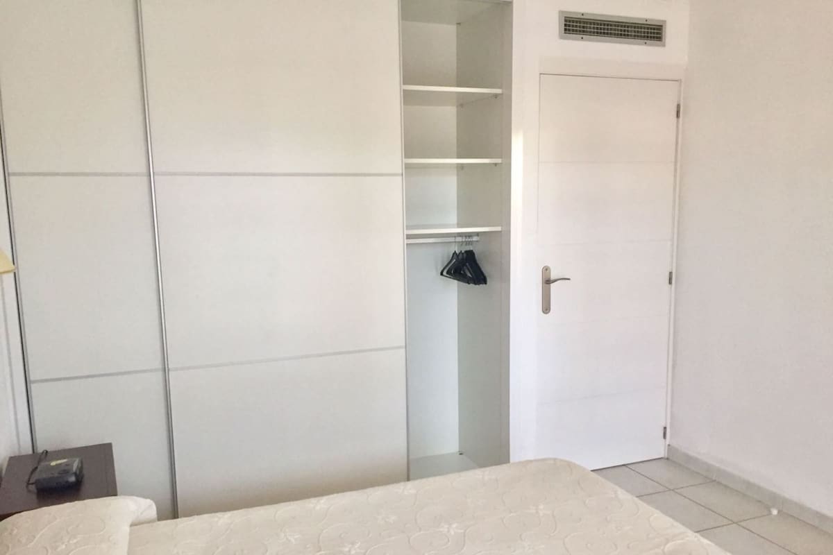 Ein Schlafzimmer mit Bett, Kleiderschrank und Tür.