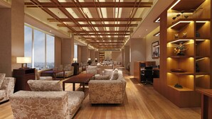 A spacious hotel lobby with patterned sofas, wooden shelves, and a city view. - Doubletree By Hilton Pune - Chinchwad (Pune)