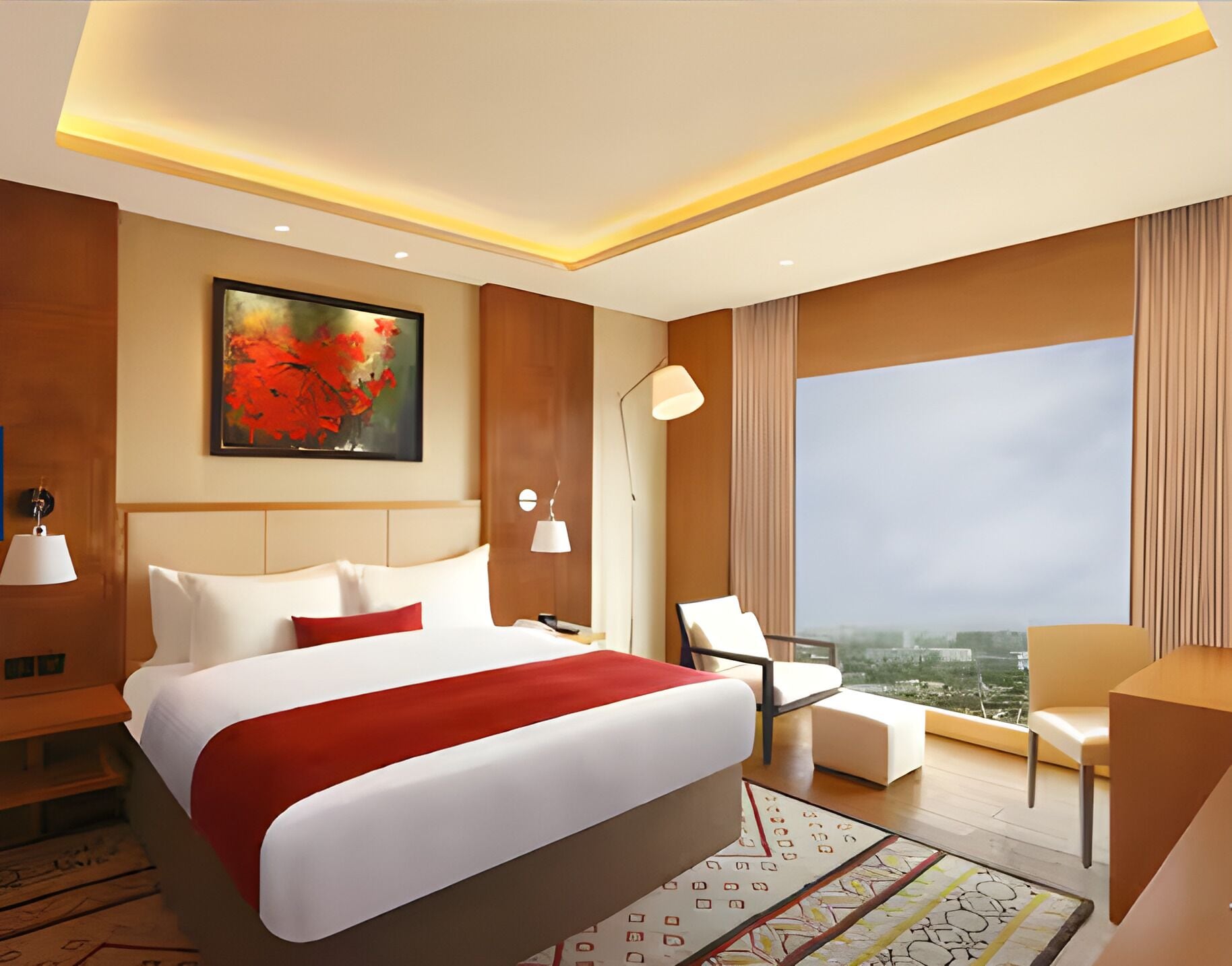 A modern hotel room with a large bed, a desk, a chair, a view of the city, and a painting on the wall.