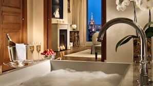 A luxurious bathroom with a bathtub, champagne, and fruit bowl. - Palazzo Parigi Hotel & Grand Spa Milan (Milan)