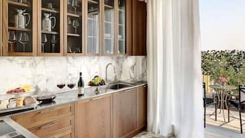 A kitchen with wooden cabinets, a marble countertop, and a sink.