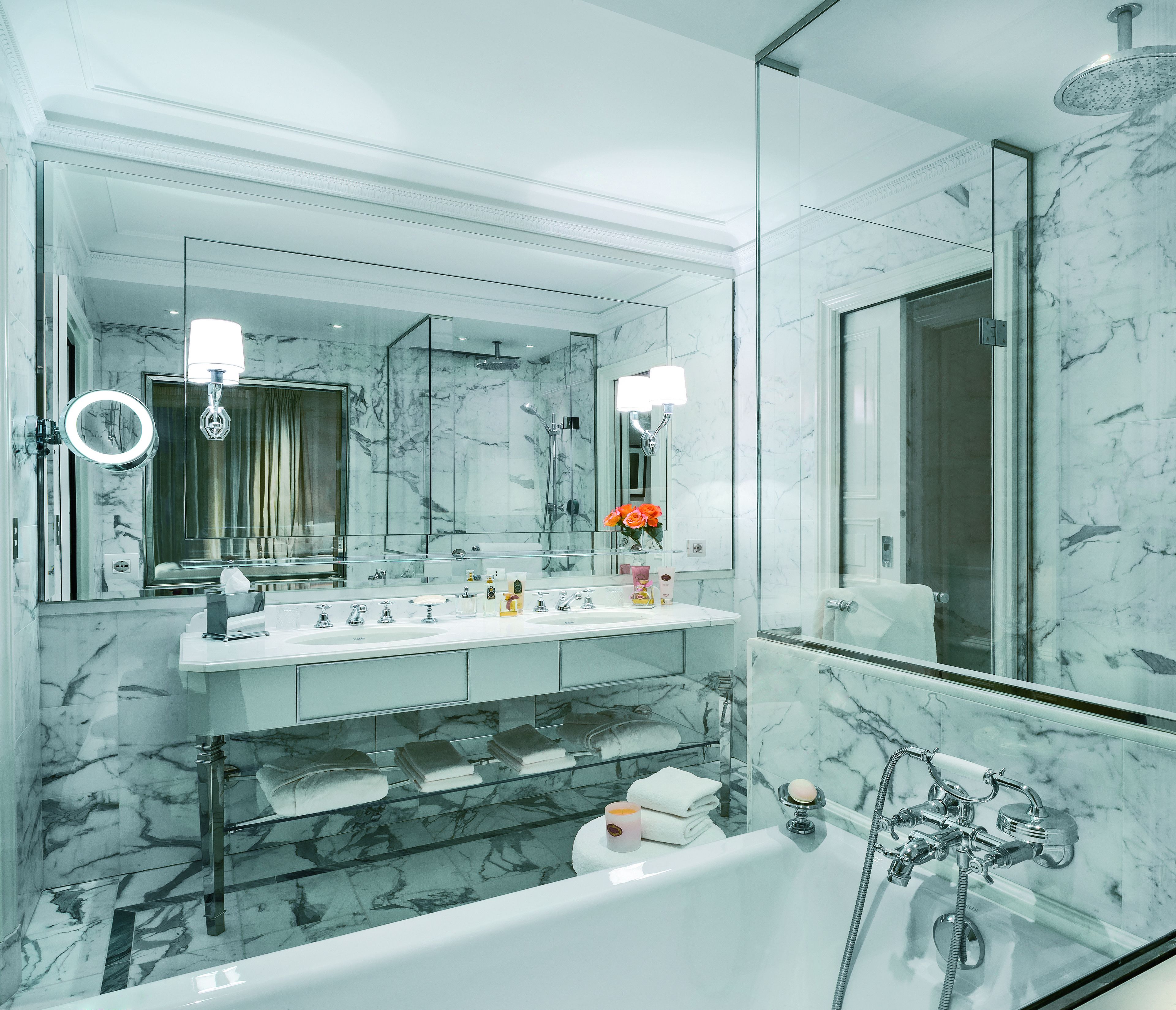 A modern bathroom with a large mirror, a bathtub, and a shower.