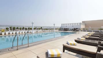 Piscine extérieure, parasols de plage, chaises longues