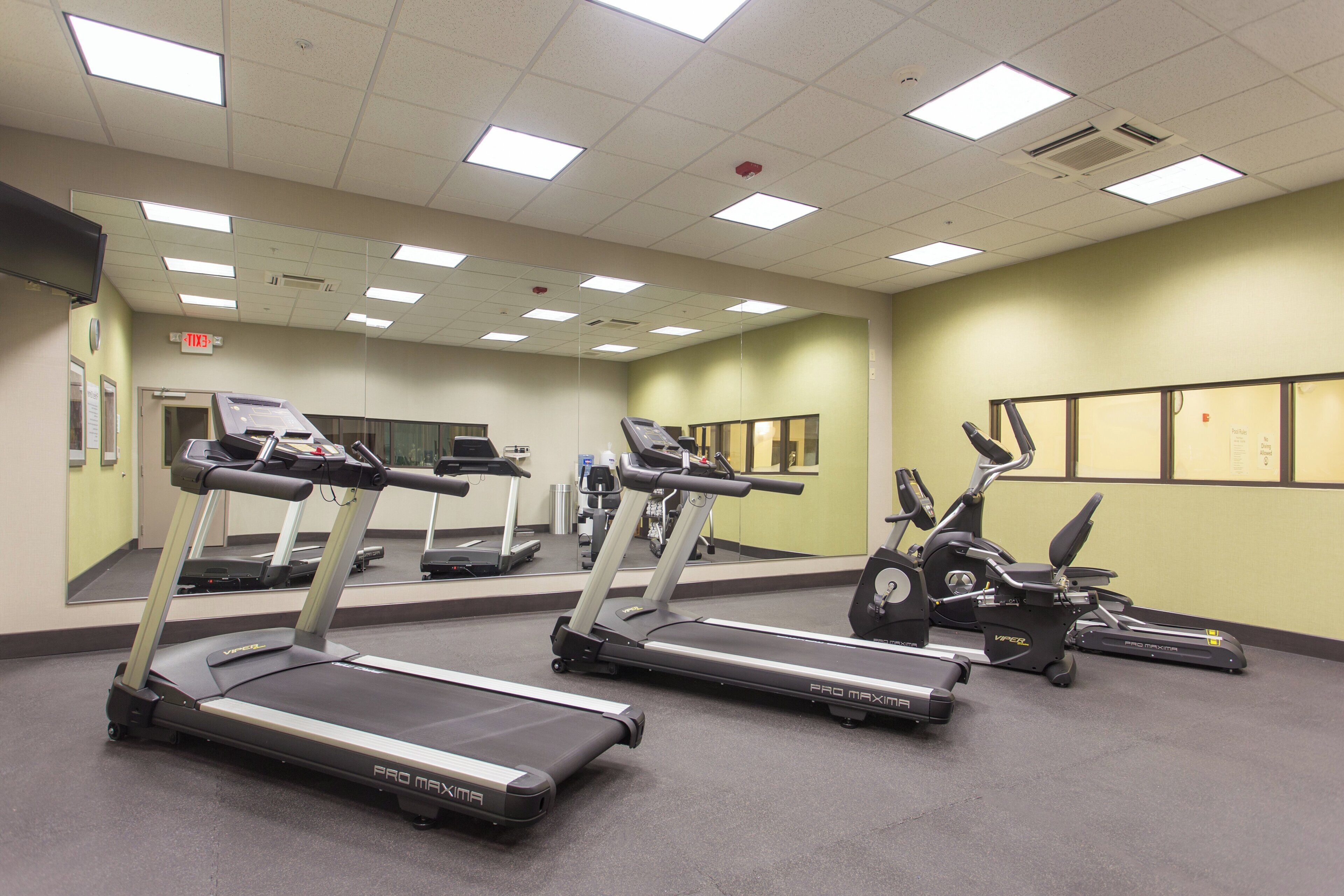A fitness center with treadmills, stationary bikes, and exercise equipment.