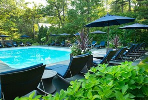 Una piscina al aire libre de temporada, sombrillas