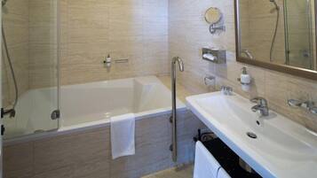Un baño con bañera, ducha, lavabo y espejo.