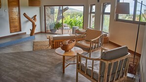 Amplia sala de estar con piso de madera, una mesa redonda y un cómodo espacio para sentarse.