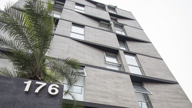 Un bâtiment moderne, sur lequel on peut voir une enseigne indiquant le numéro « 176 » et le logo de la chaîne « BRAVIA Hotels ».