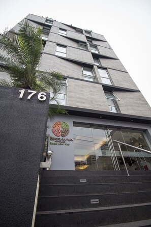 Un bâtiment moderne, sur lequel on peut voir une enseigne indiquant le numéro « 176 » et le logo de la chaîne « BRAVIA Hotels ».