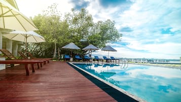 Een buitenzwembad, parasols voor strand/zwembad