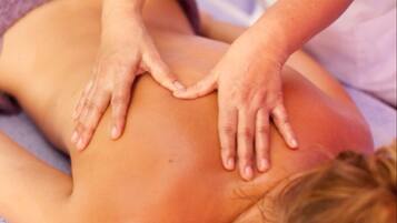 A massage therapy session with a focus on the back and shoulders.