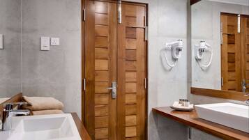 Un baño moderno con dos lavamanos, puertas de madera y un espejo grande.