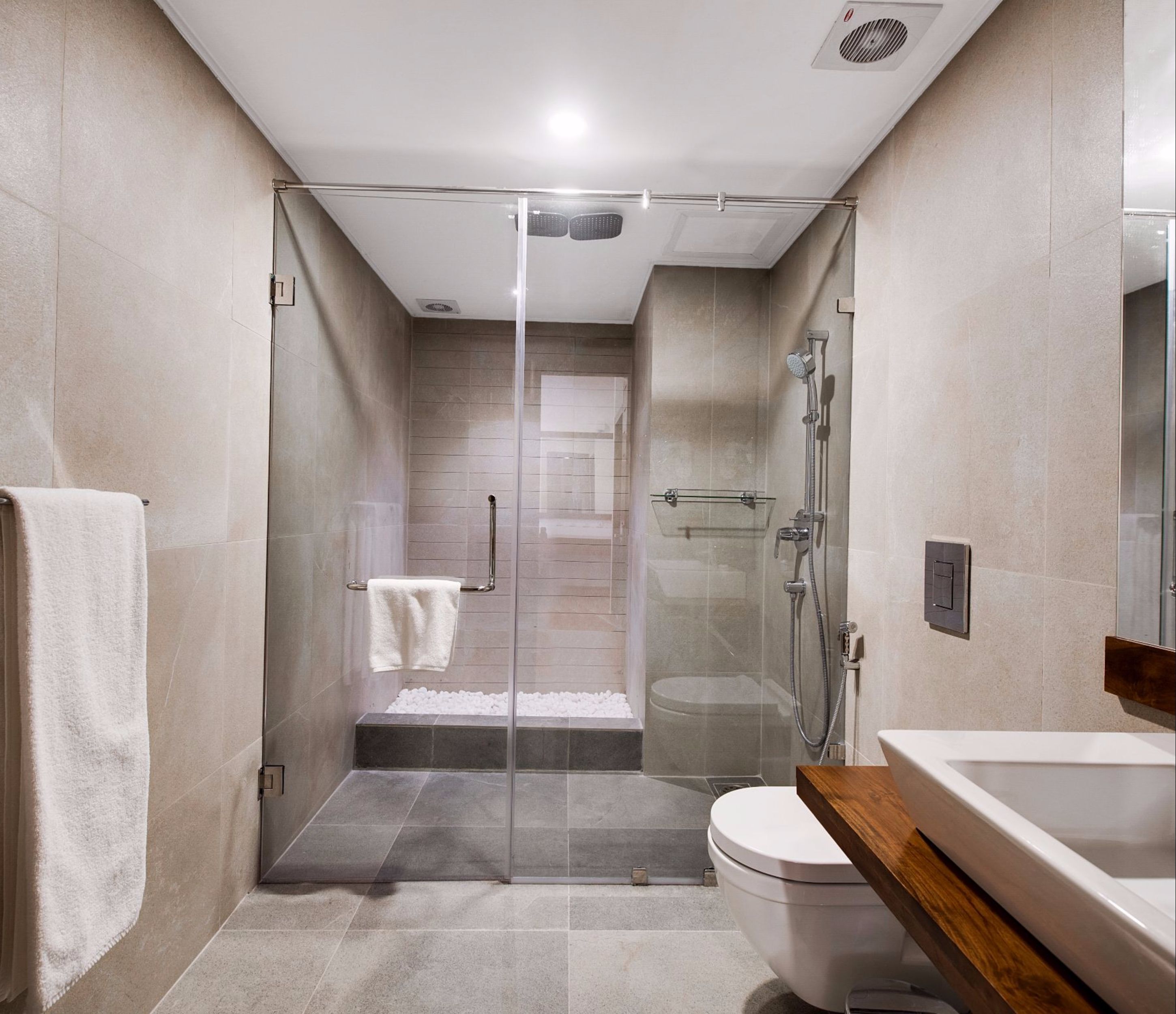 Un baño moderno con ducha de vidrio, inodoro y lavamanos.