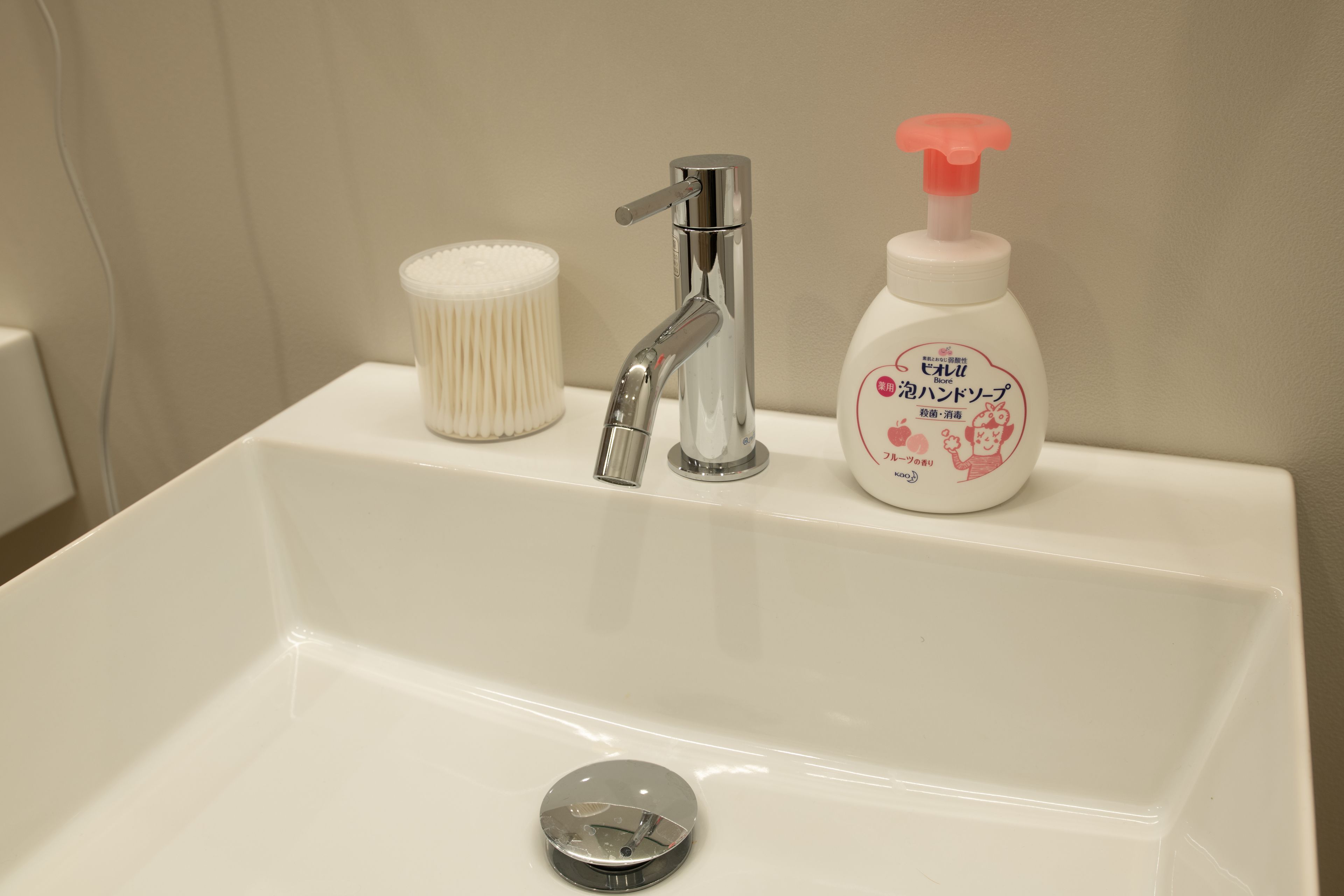 A bathroom sink with a faucet, a soap dispenser, and a soap bar.