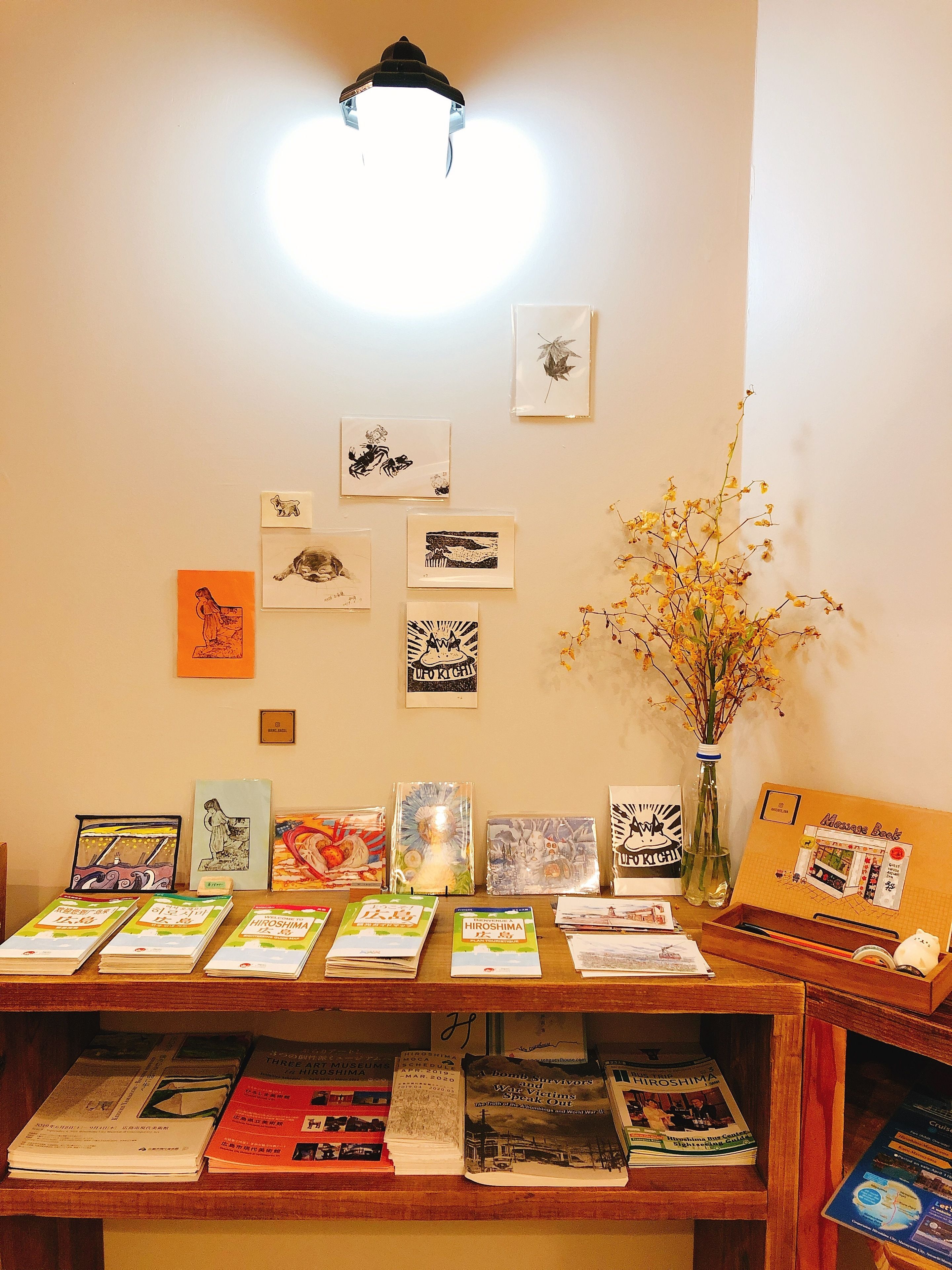 A book display with various books and framed artworks on a wooden table.
