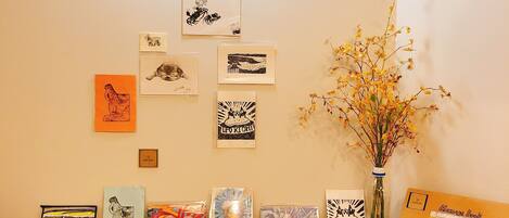 A book display with various books and framed artworks on a wooden table.