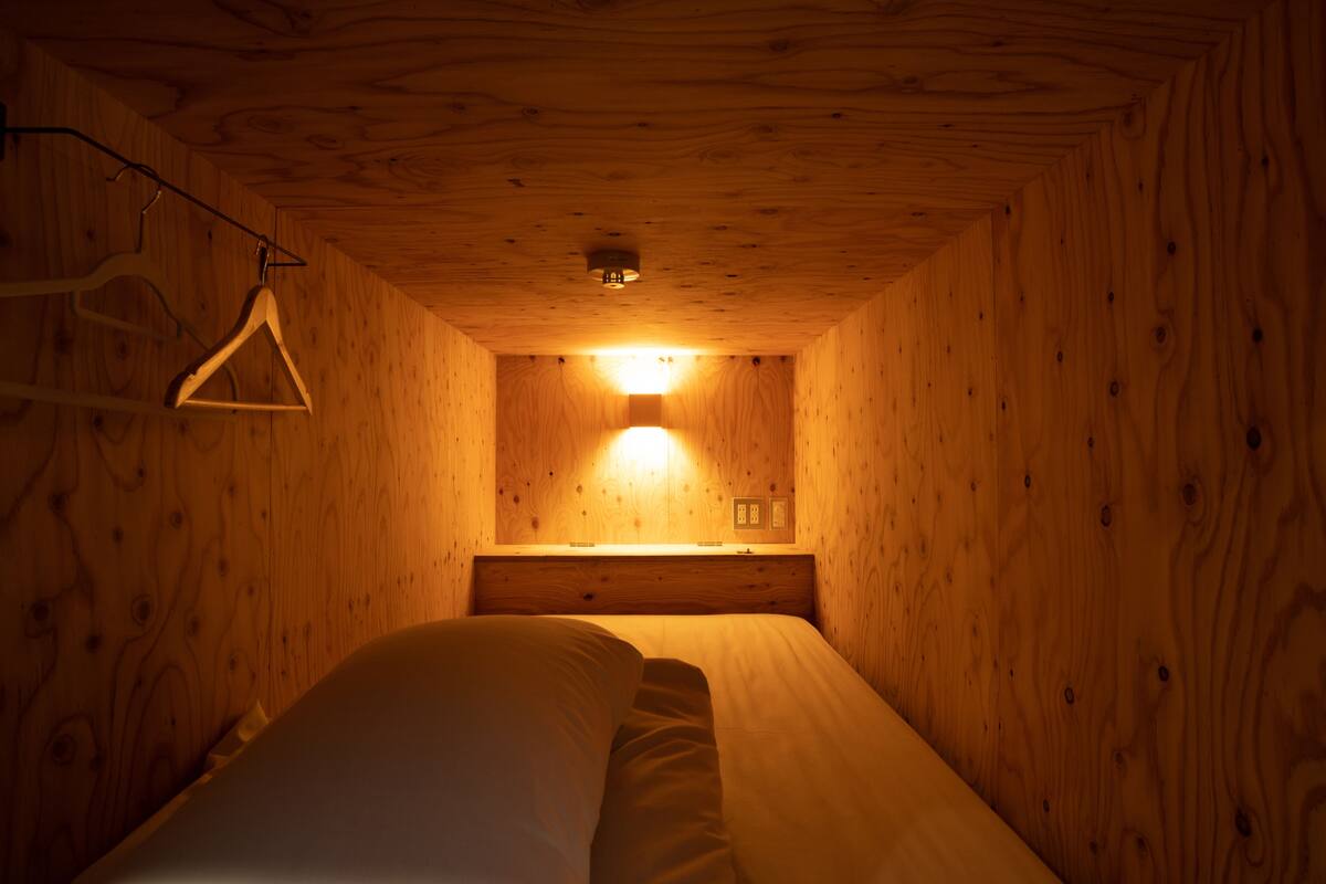 A small, cozy room with wooden walls and a bed.