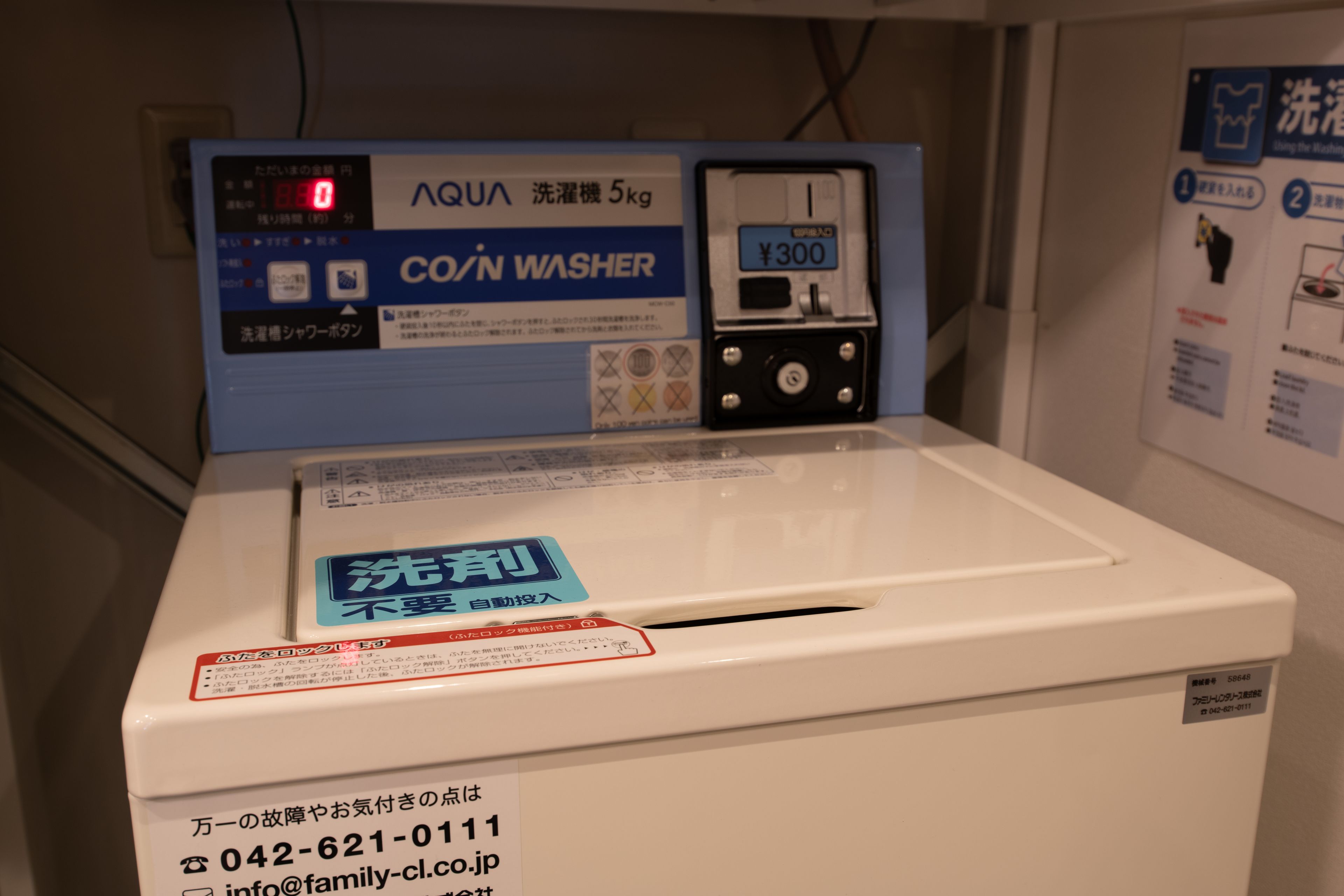 A white washing machine with a blue control panel and a price tag of ¥300.