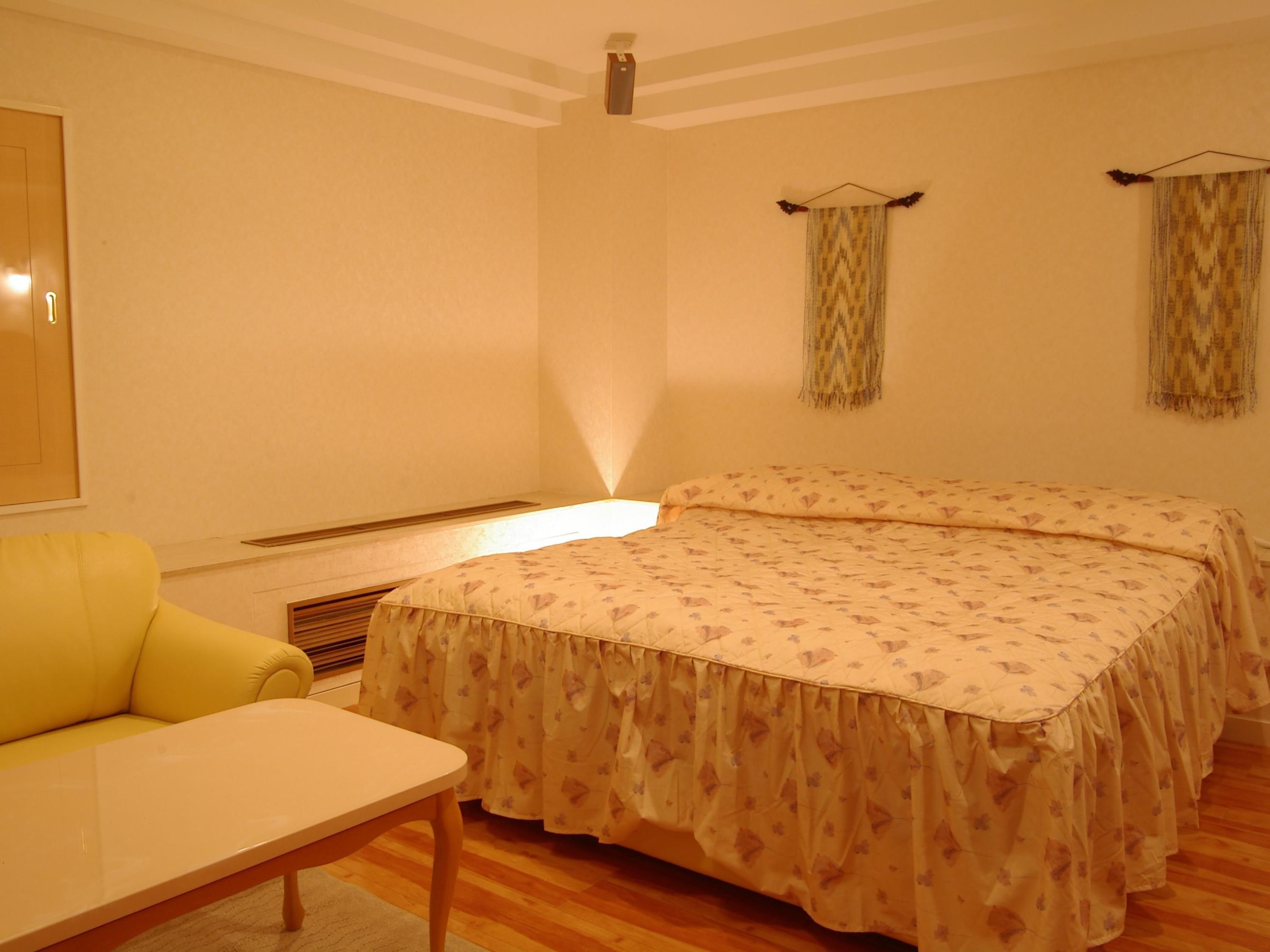 A room with a bed, a small table, and a chair.