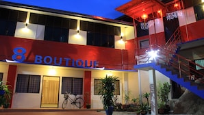 A building with a sign reading "8 BOUTIQUE" and a staircase leading to an upper level. - 8 Boutique By The Sea (George Town)