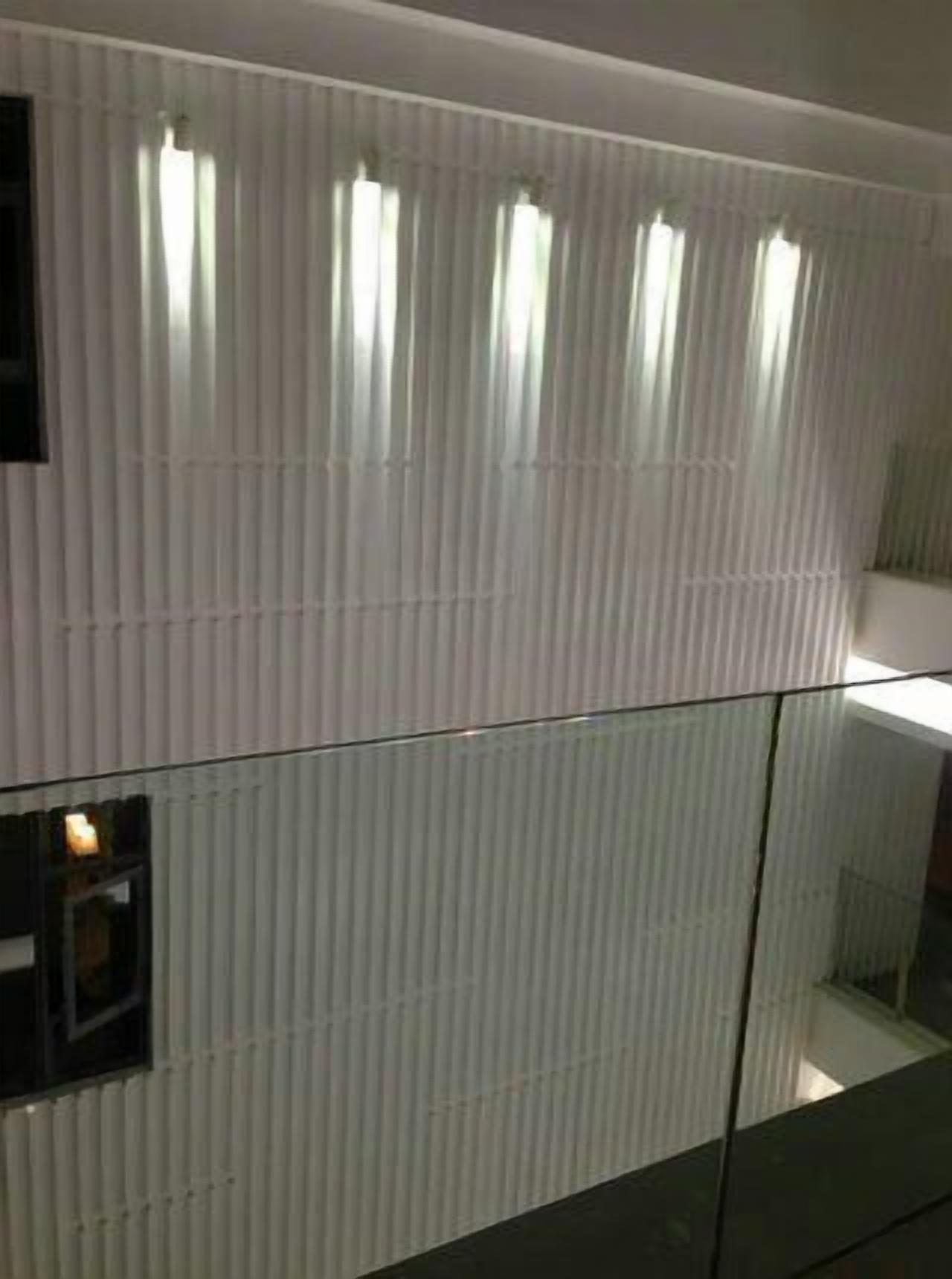 A modern room with vertical paneling and a glass partition.