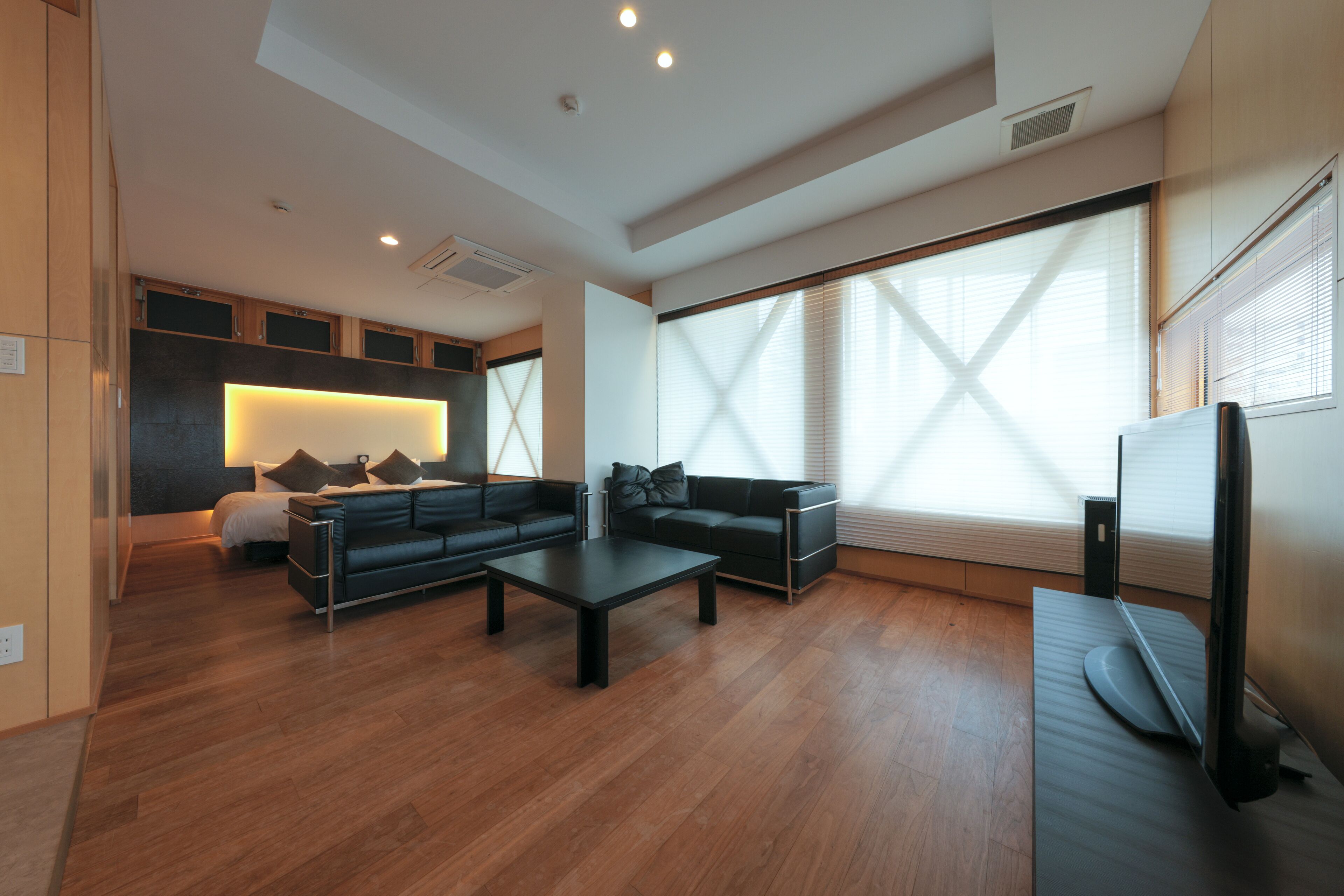 Un salon moderne avec un canapé, une table basse et un téléviseur à écran plat.