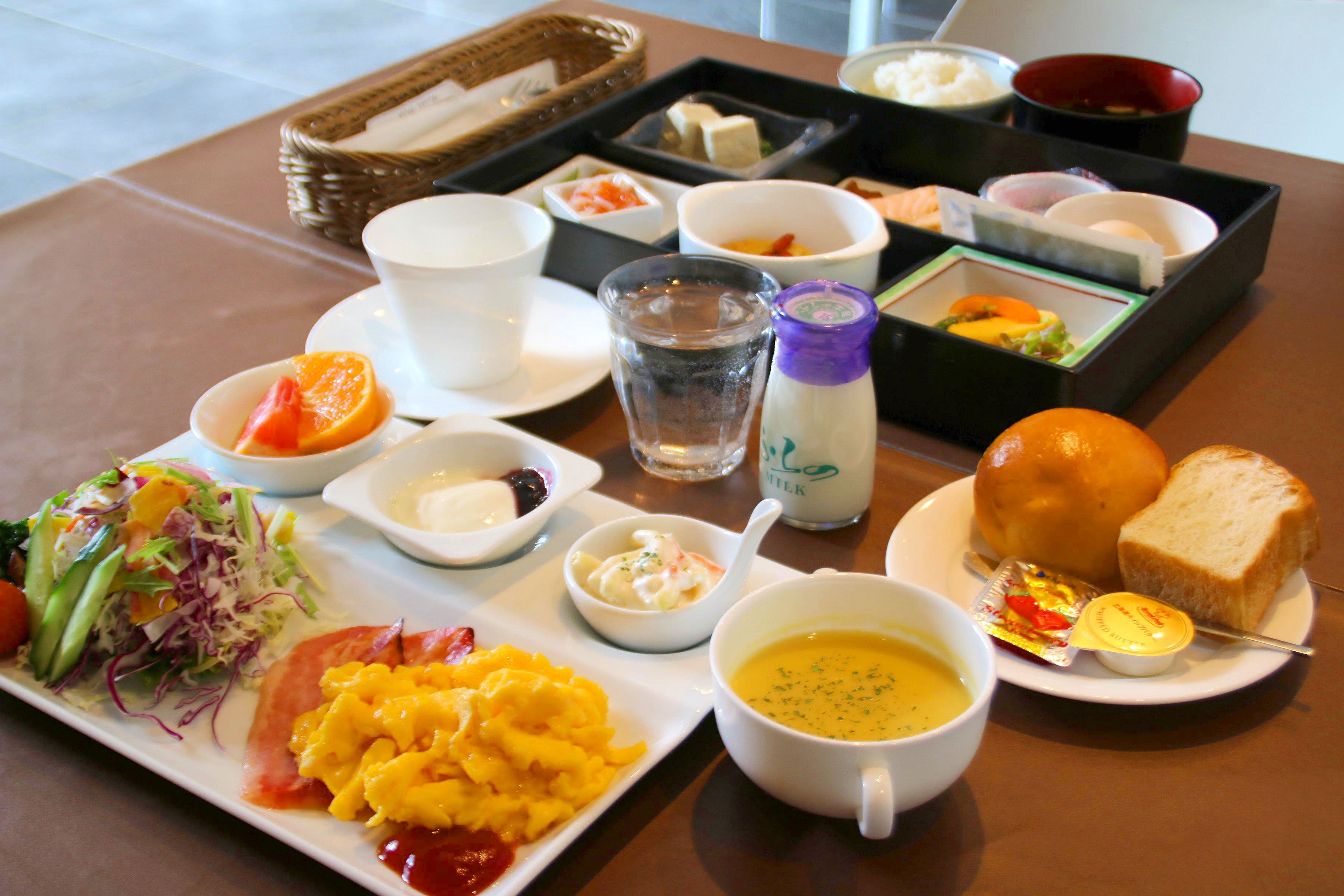 Bandeja de desayuno con diversos platillos, incluyendo huevos, tostadas, sopa y ensalada.