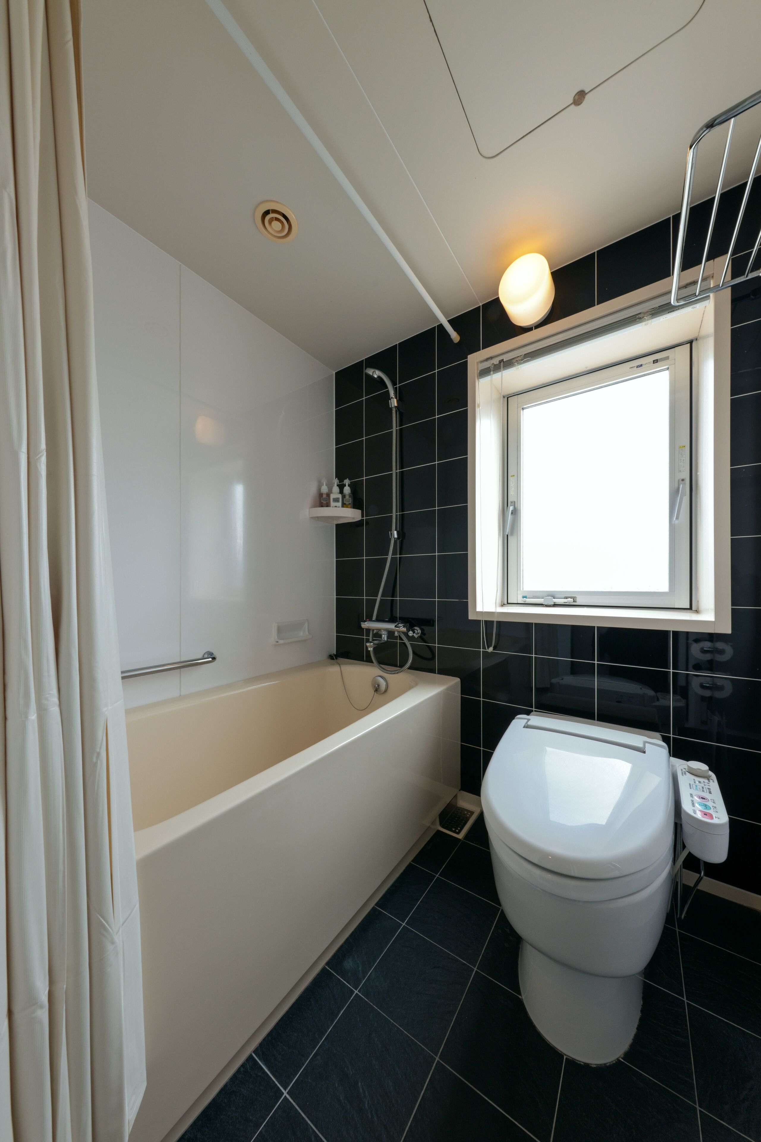 Un bagno con vasca, water e finestra.