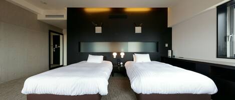 Una habitación de hotel moderna con dos camas, un espejo grande y vistas a la ciudad.