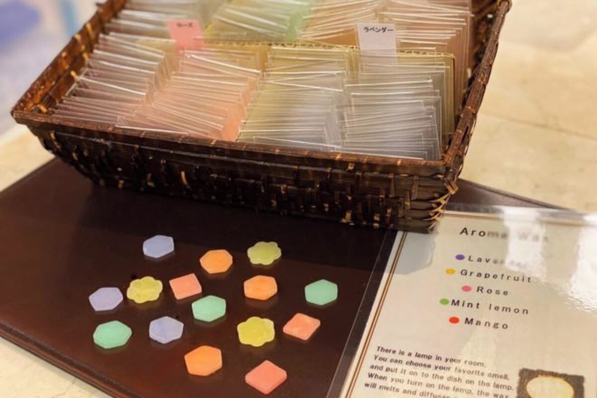 Een presentatie van geurkaarsen met labels die verschillende geuren aangeven, zoals lavendel, grapefruit, roos, munt-citroen en mango.