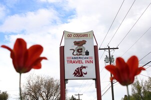 Un letrero para el American Travel Inn, con un felino como mascota y un logotipo.