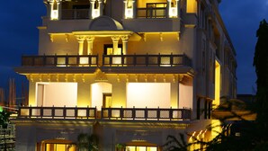 Un hôtel à plusieurs étages, sur le toit duquel on peut voir un grand panneau lumineux avec l’inscription « MATRIX », doté de balcons et d’une façade bien éclairée.