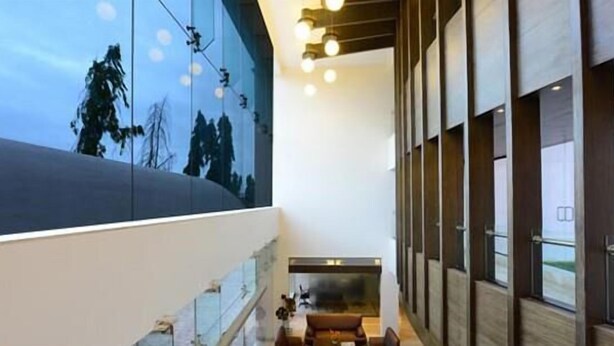 Un intérieur moderne avec une grande fenêtre, une cheminée et un coin salon.