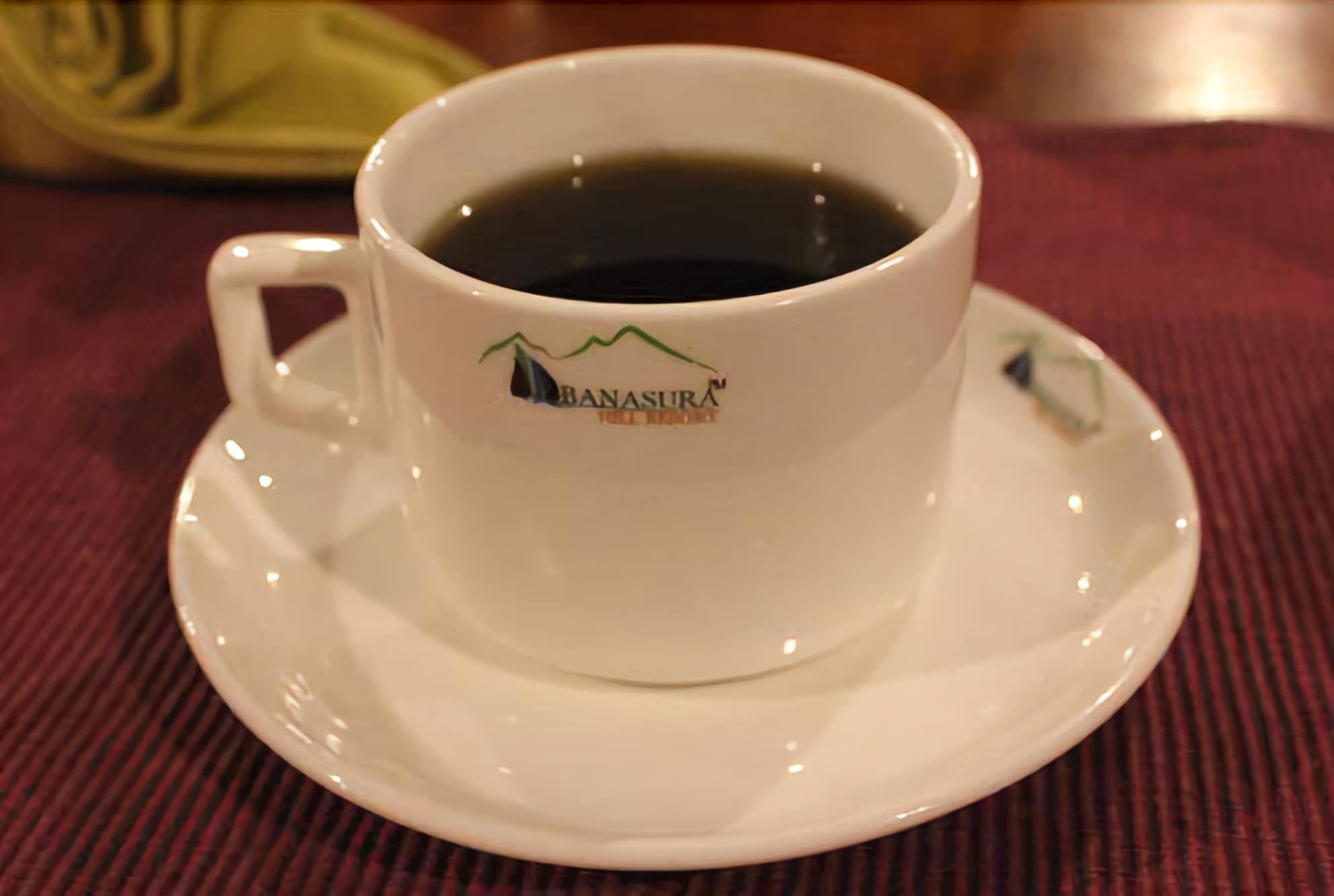 A white cup and saucer with a logo and text on the cup.