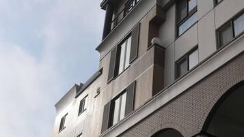 A multi-story building with a modern architectural design, featuring balconies and large windows.