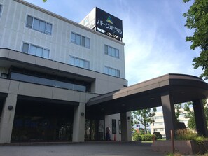 A modern building with a large sign, a covered entrance, and a parking area. - Hakodate Park Hotel (Hakodate)