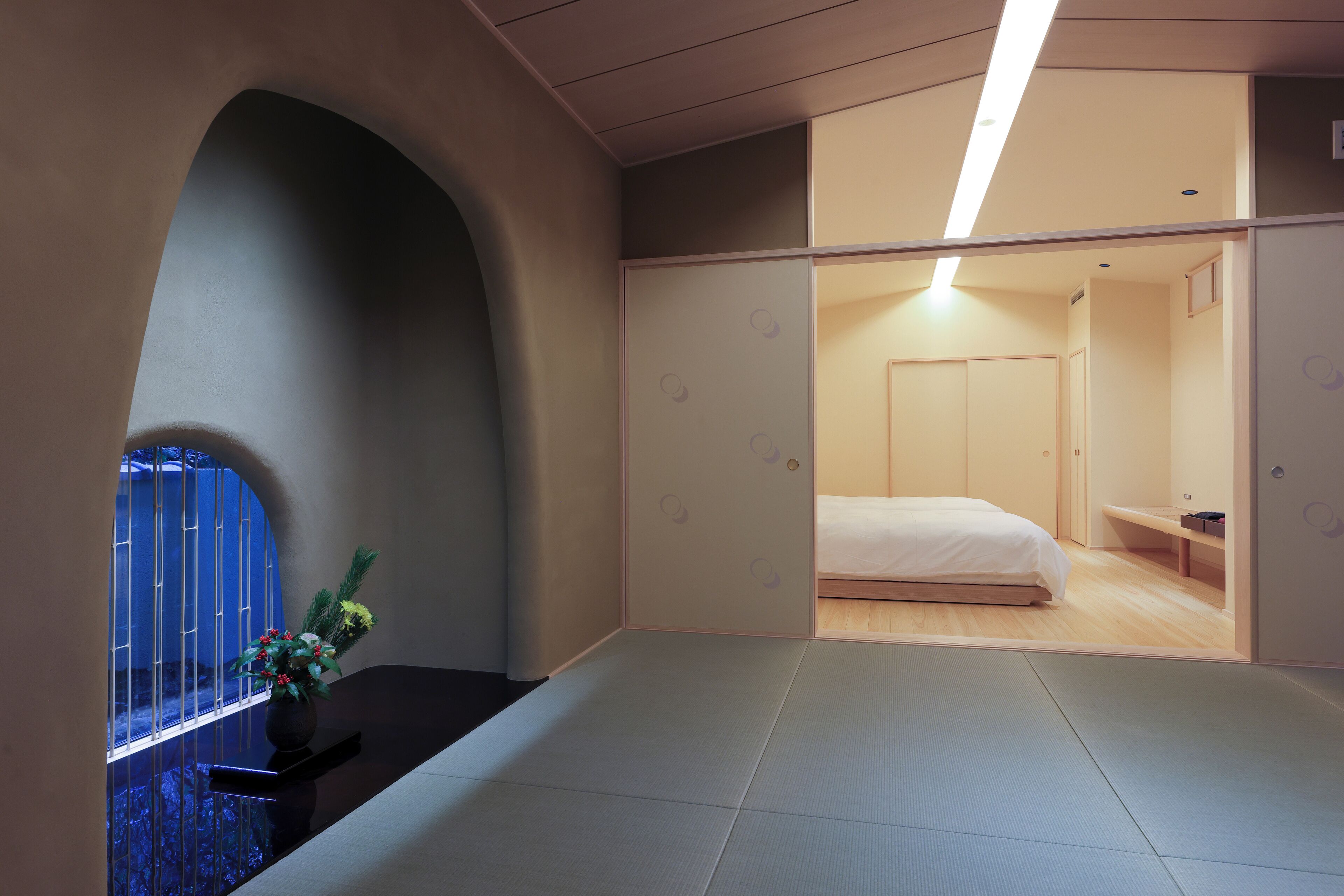 A modern bedroom with a bed, a bedside table, and a small shelf.