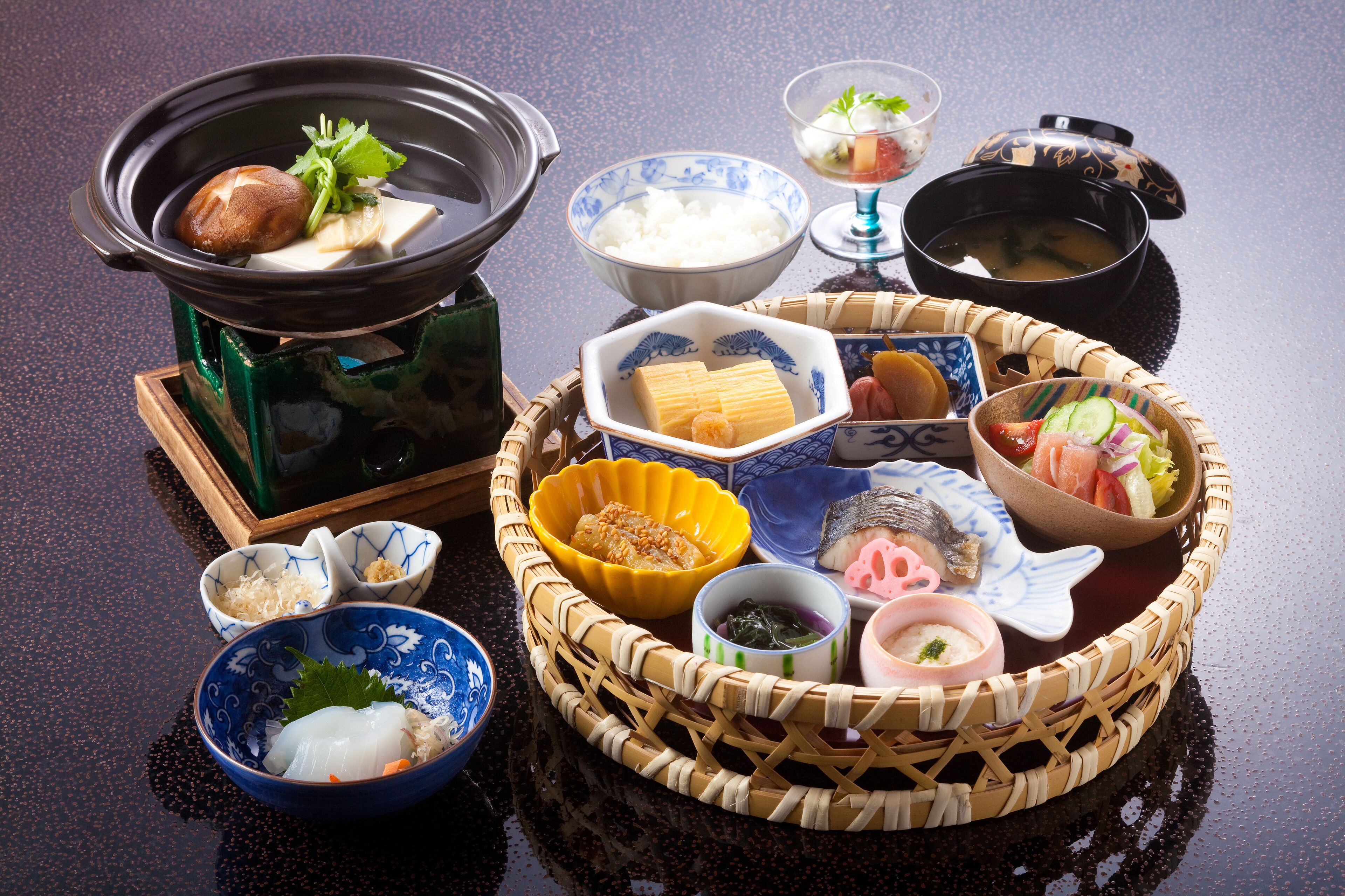 Un repas japonais traditionnel, composé de différents plats et d’un plat mijoté servi à table.