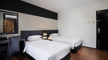 A hotel room with two beds, a desk, a chair, and a wardrobe.